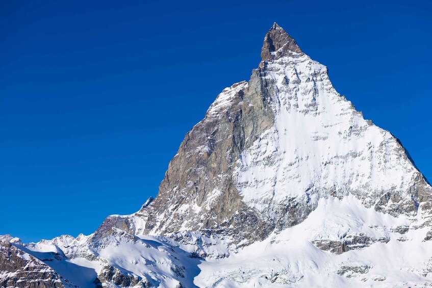 A snow-covered mountain peak with a sharp peak and rugged terrain. 5