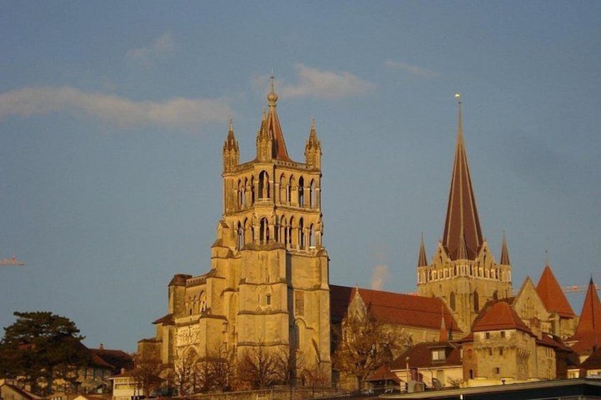 Eine historische Kathedrale mit einem markanten Turm und einem schlanken Kirchturmspitze. 2