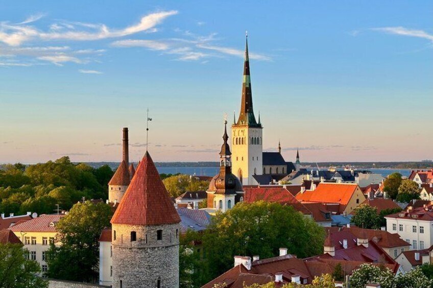 Eine Stadt mit einem markanten Kirchturm, einem Steinturm und Gebäuden mit roten Dächern. 1