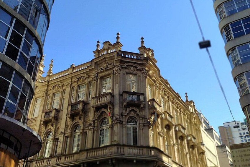 A historic building with ornate architecture, large windows, and a balcony. 3
