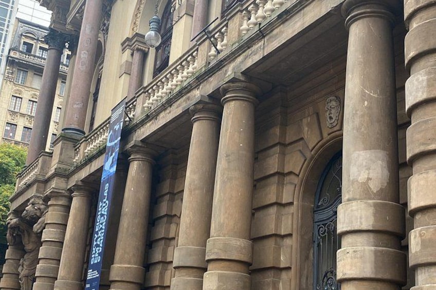 A classical building facade with large columns and an ornate entrance. 2