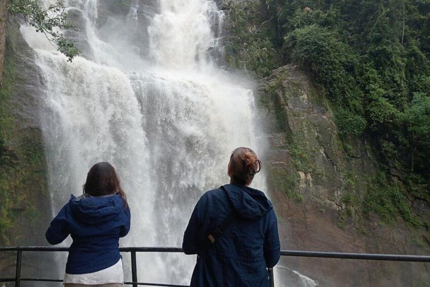 Two people standing by a waterfall. 5