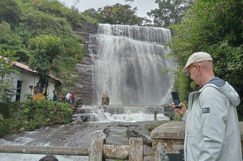 A waterfall, a statue, and a person taking a photo. 4