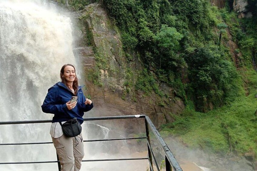 A person standing on a bridge with a waterfall in the background. 3