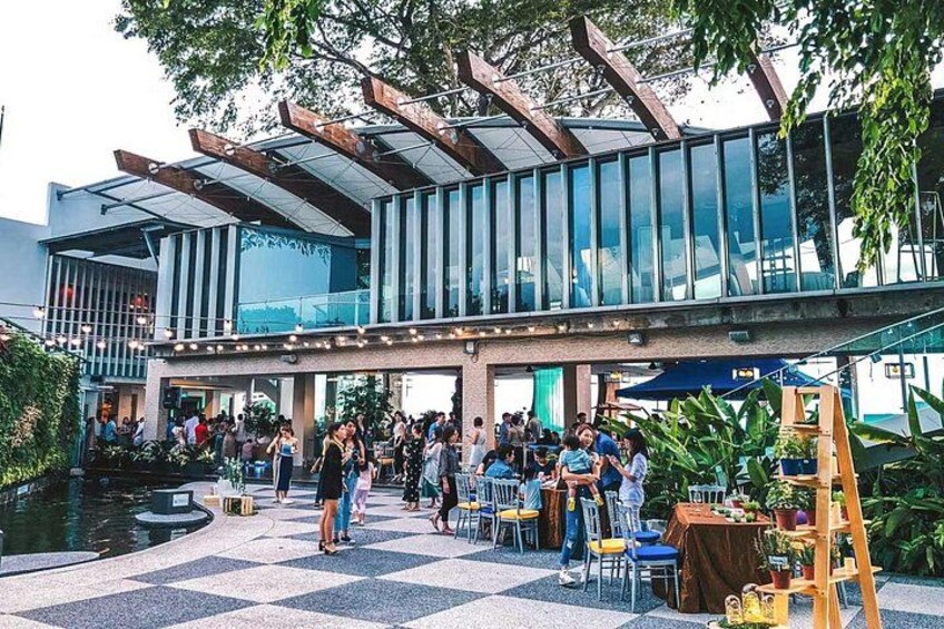 An outdoor café with people dining, a modern building with glass windows, and a checkered floor. 4