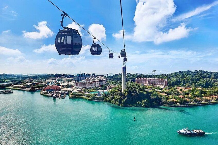 A cable car system, a body of water, and buildings in the background. 1