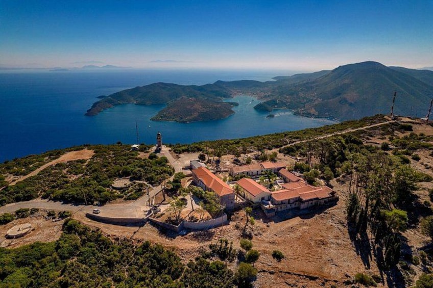 A coastal landscape with a small settlement, a lighthouse, and a large body of water. 2