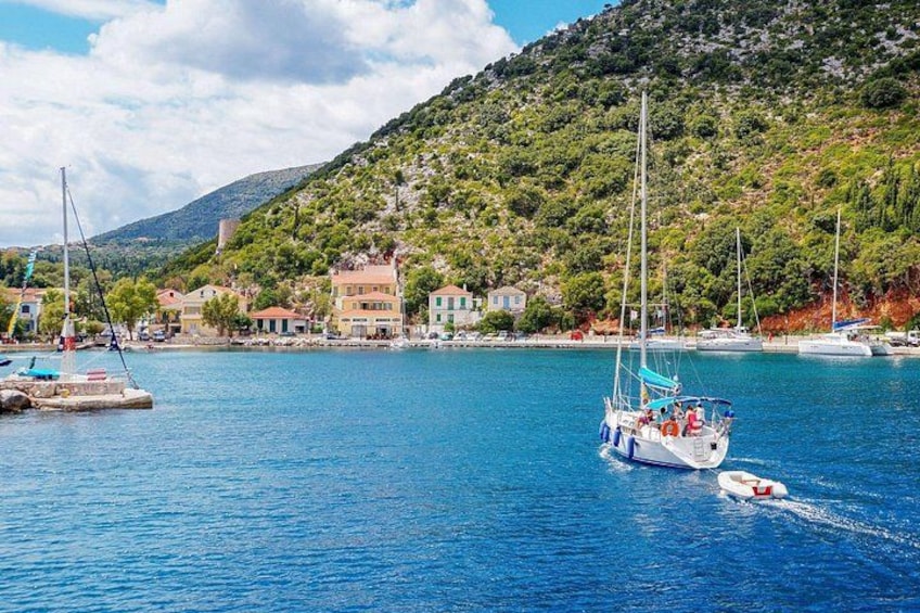 A coastal town with boats, a hill with greenery, and buildings. 2