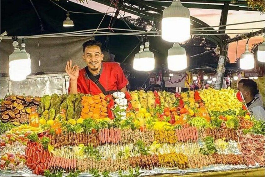 A vendor at a market stall with a variety of fresh vegetables and fruits. 5