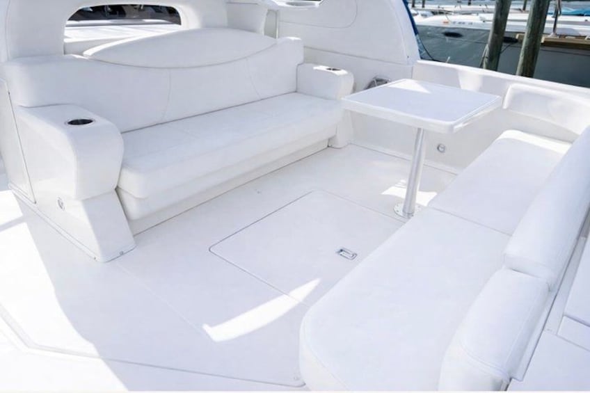 Un pont de bateau blanc, équipé de sièges et d’une table. 3