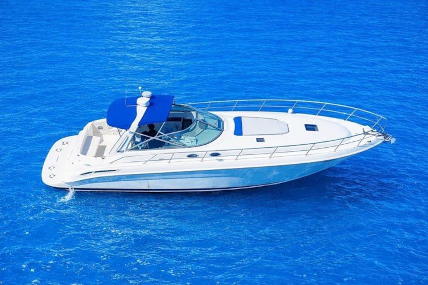 Un yacht blanc avec un auvent bleu, voguant sur une mer bleue. 1