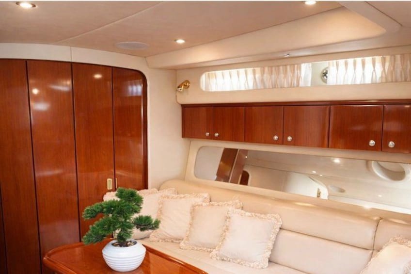 Un intérieur de cabine luxueux, avec des meubles en bois, un banc rembourré et une plante en pot. 4