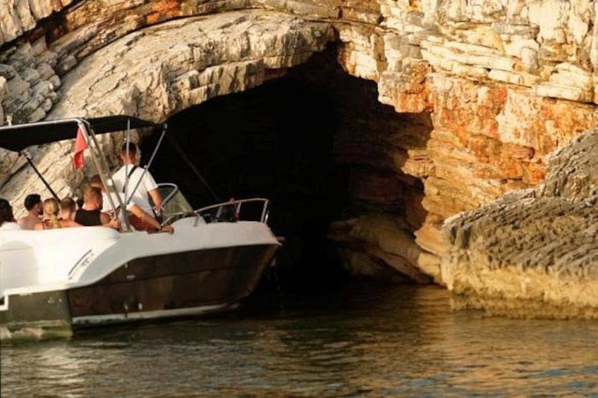 A boat navigating through a rocky cave entrance. 1