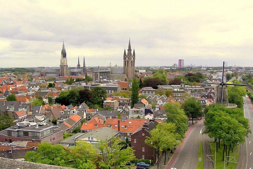 A cityscape with historic buildings, a prominent church tower, and a modern skyscraper in the distance. 3
