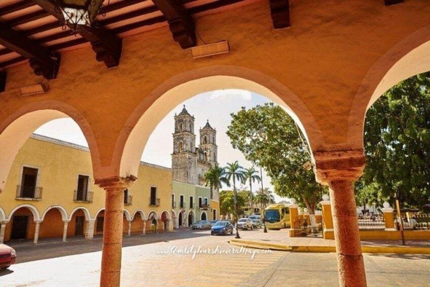 An architectural structure with arches, a building with a bell tower, and palm trees. 4