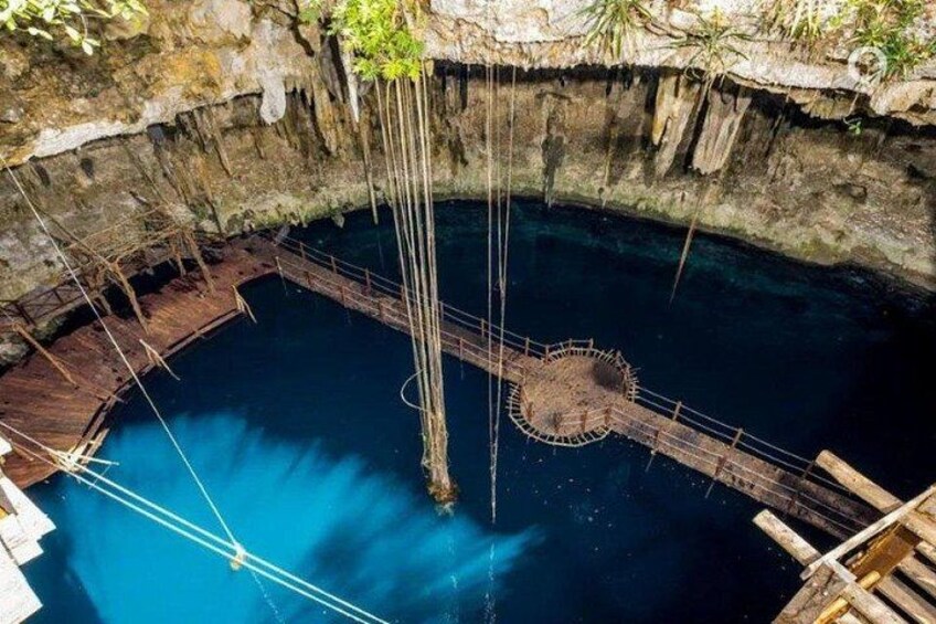 A circular stone structure in a body of water, surrounded by wooden walkways and ropes. 1