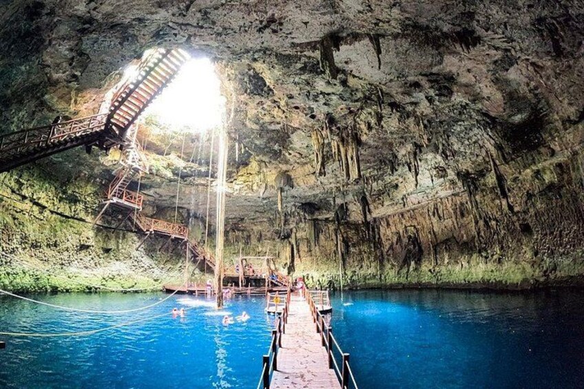 A cave with a swimming pool, a wooden staircase, and a metal bridge. 2