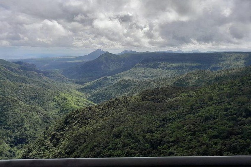 A mountainous landscape with dense green vegetation and a cloudy sky. 2