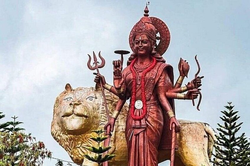 A large statue of a deity with multiple arms, standing on a lion. 3