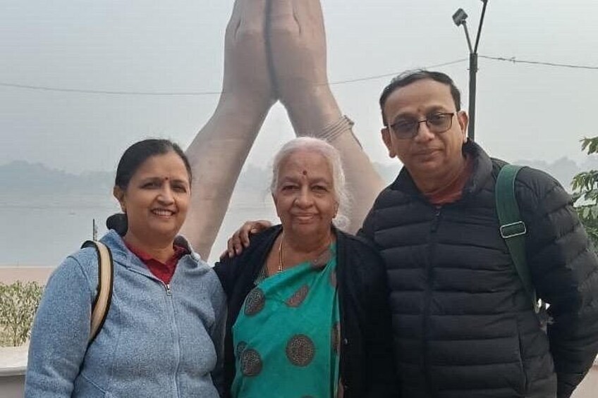 Drei Personen stehen vor einer großen Statue. 2