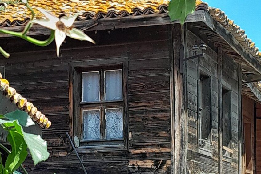 Une maison rustique en bois, avec un toit en tuiles et une fenêtre ornée de vitraux décoratifs. 3