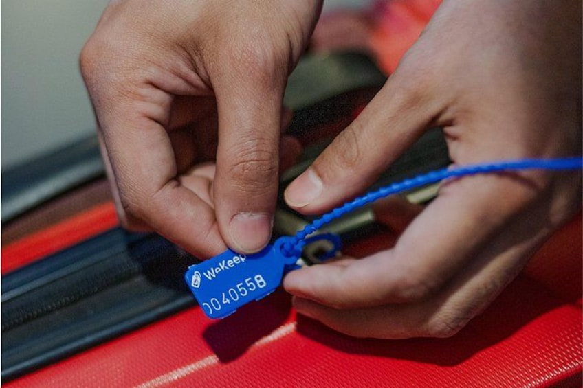Hands holding a blue object with a label. 1