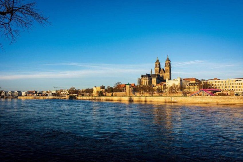 A river with a cityscape in the background, including a prominent building with two towers. 2