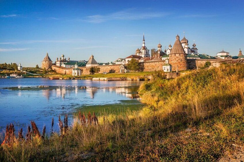 A historic fortress with domed towers by a calm river. 3