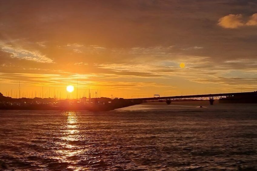 A sunset over a river with a bridge in the distance. 5