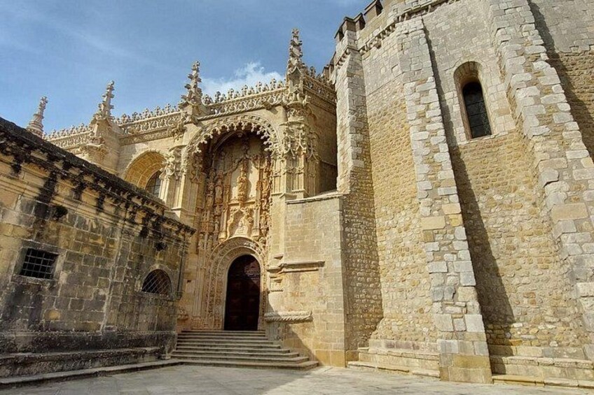 A historic stone building with ornate arches and a large wooden door. 5
