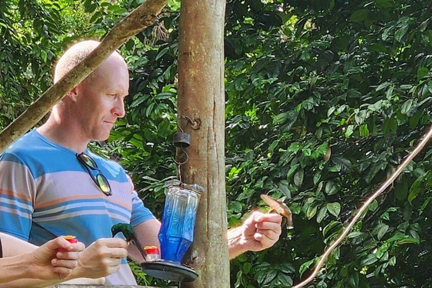 Una persona alimentando un pájaro desde un comedero colgante. 3