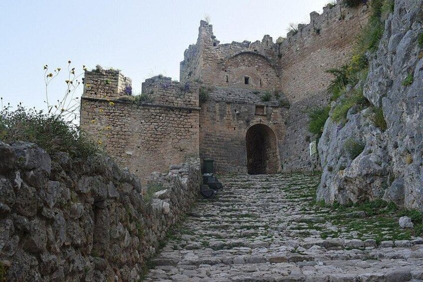 A stone pathway leading to a medieval castle entrance. 4