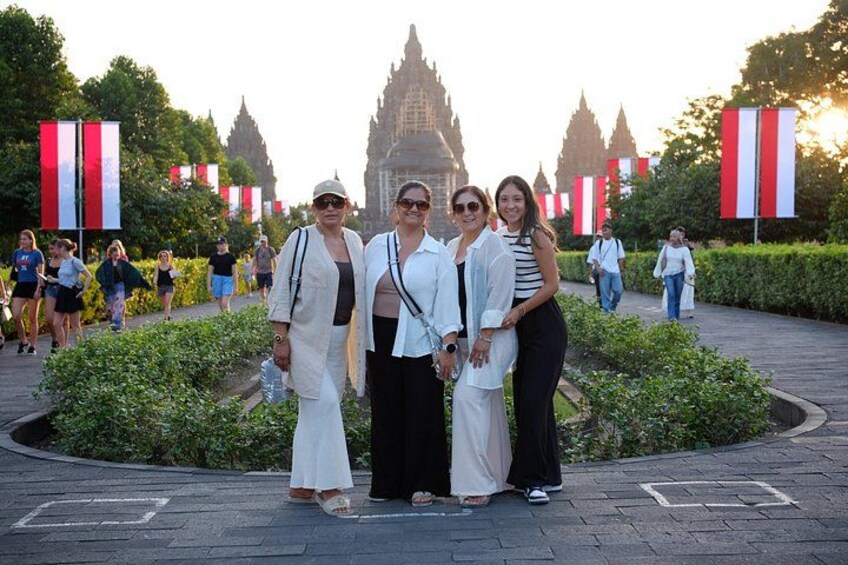 A group of people standing in a park with a large building in the background. 5