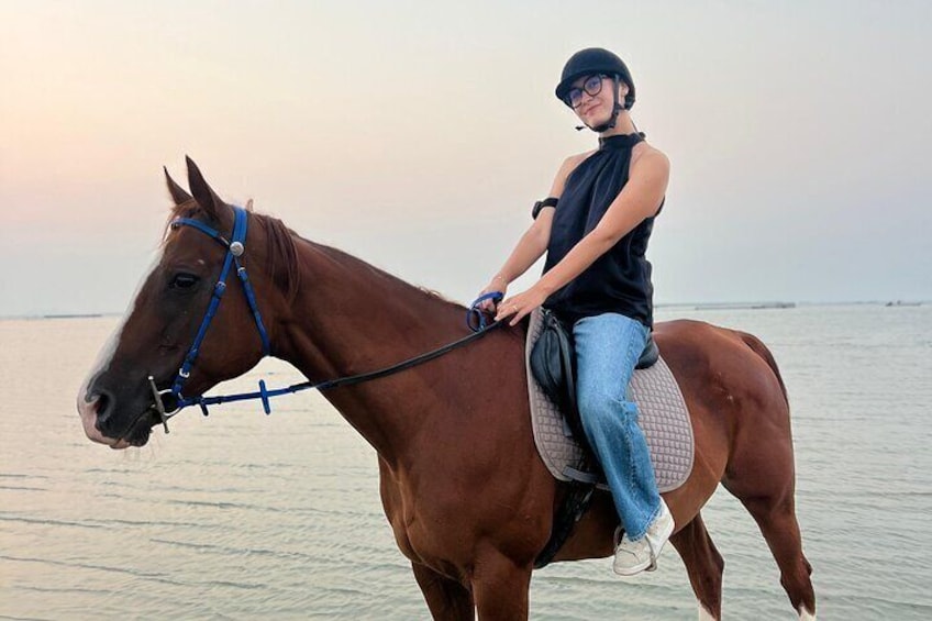 A person riding a horse by the water. 1