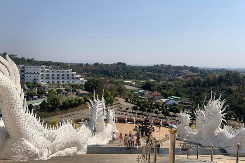 A white dragon sculpture, a building, and a distant landscape. 2
