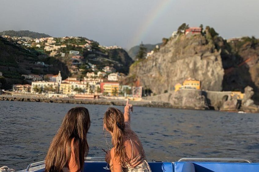 Zwei Personen in einem Boot, eine Küstenstadt und ein Regenbogen. 5