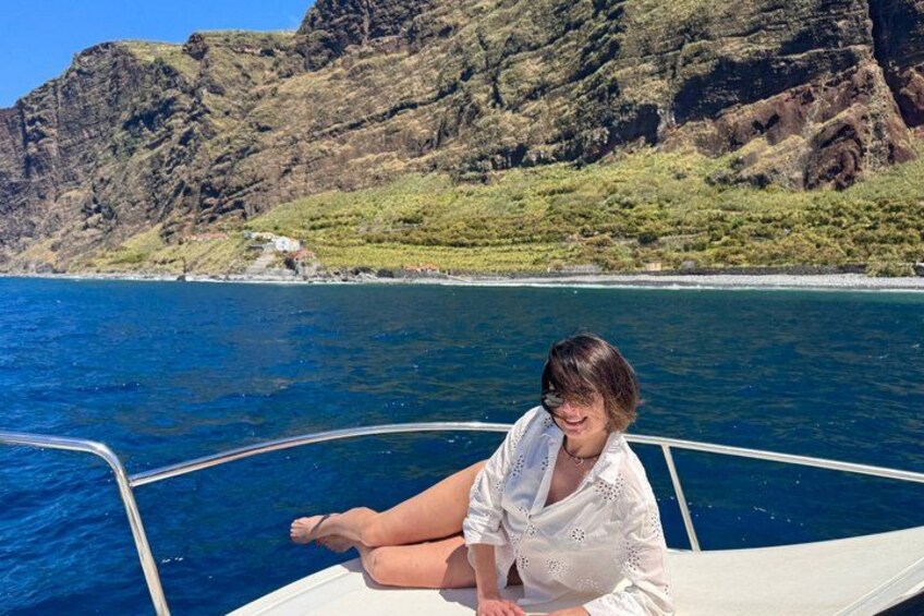 Une personne à bord d’un bateau, avec une côte montagneuse en arrière-plan. 4