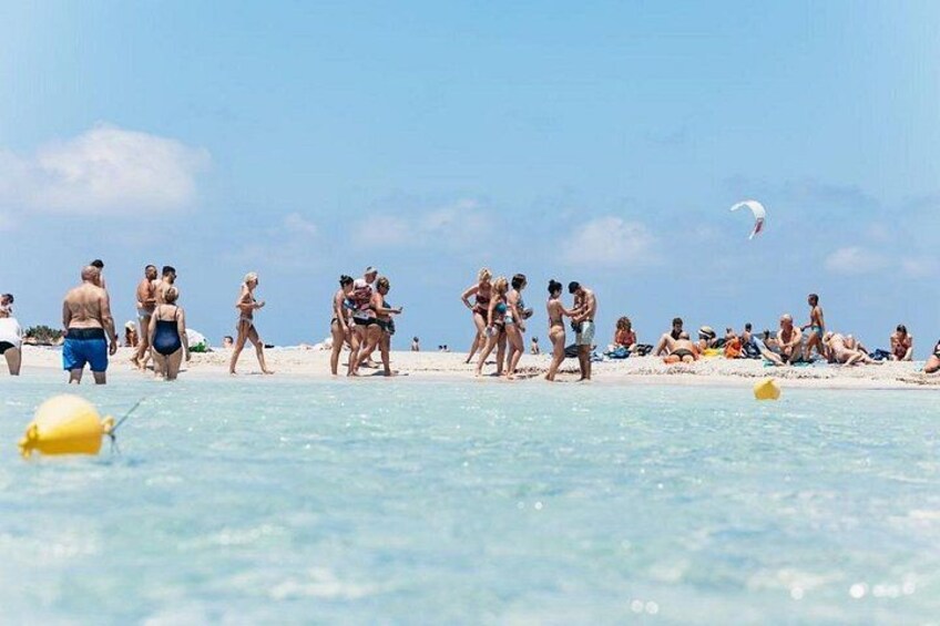 En strand där folk solar och badar. 5