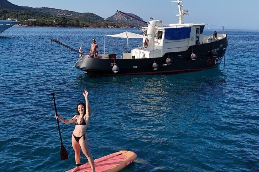 A woman on a paddleboard in the water with a boat in the background. 4