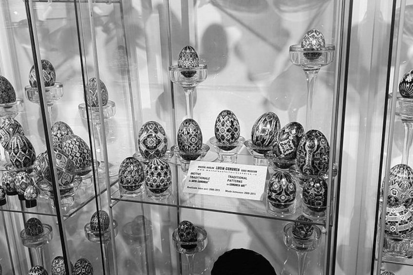 A display of intricately decorated Easter eggs in a glass case. 4
