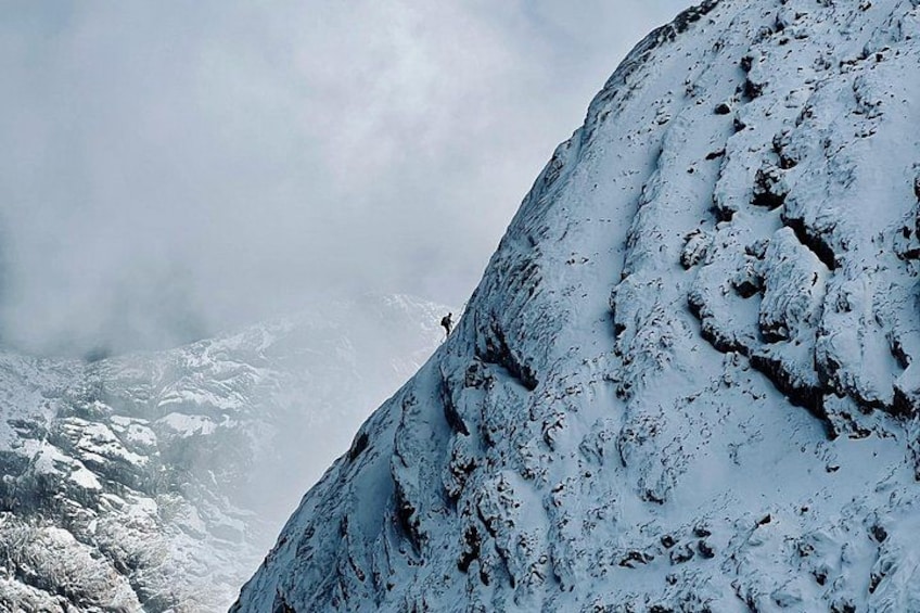 A snow-covered mountain with a person climbing. 3