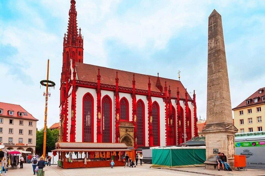A red church with a tall obelisk in front. 5