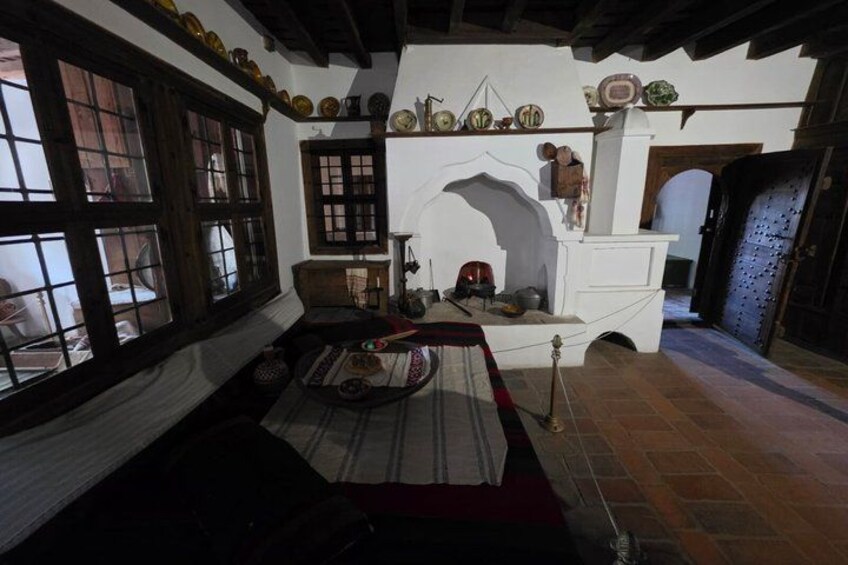 A traditional room with wooden beams, a fireplace, and a bed with a striped blanket. 2
