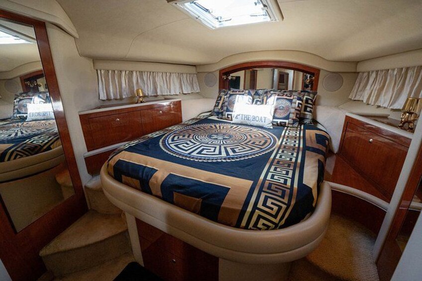 A luxurious cabin with a large bed, a vanity, and a mirror. 2