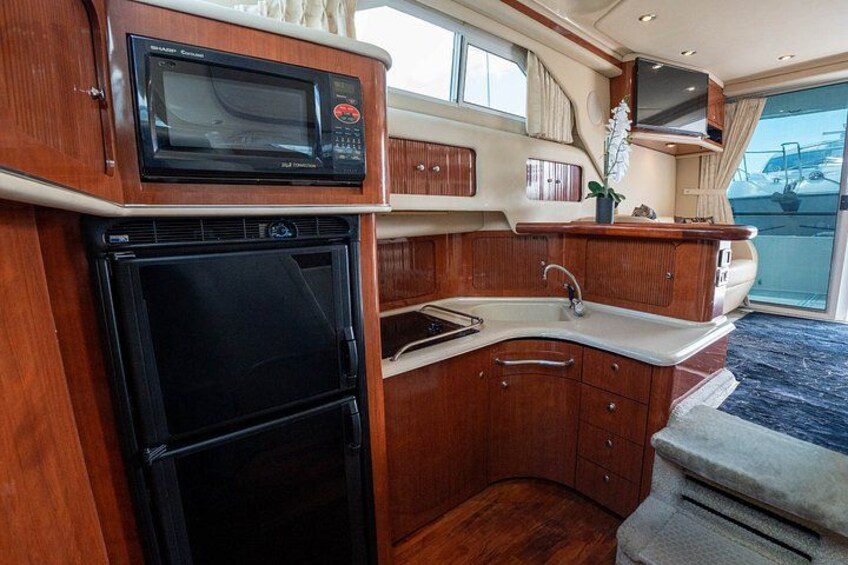 A compact kitchen with a microwave, oven, and sink. 3