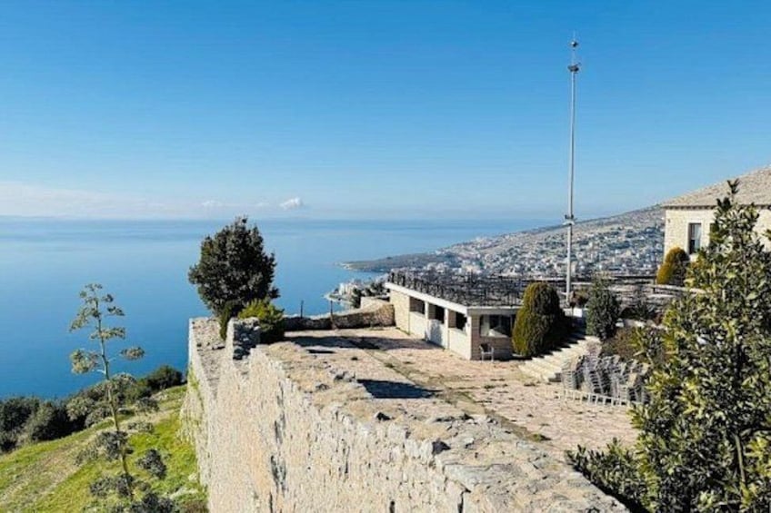 A coastal fortification with a clear view of the sea and a distant cityscape. 2
