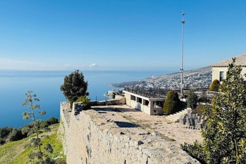 A coastal fortification with a clear view of the sea and a distant cityscape. 5