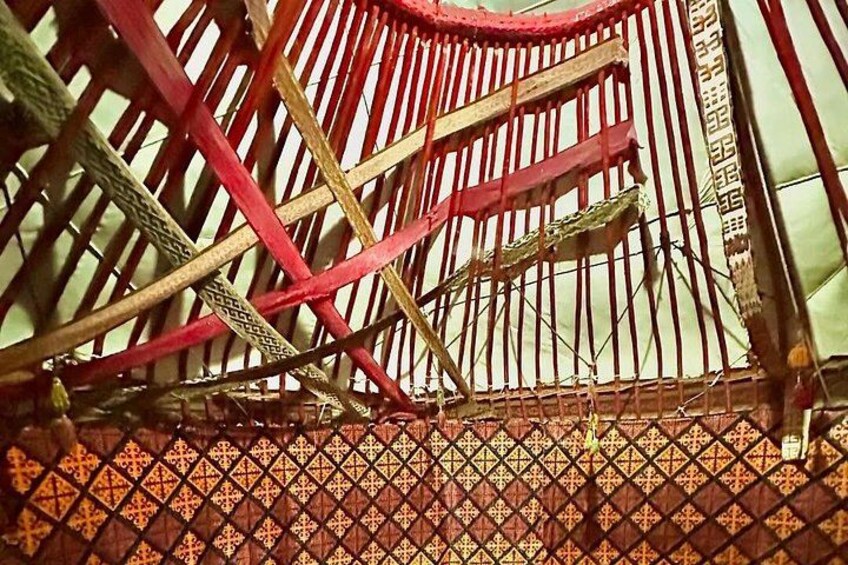 A wooden structure with a patterned floor and a red and yellow striped roof. 5