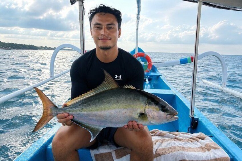 A person holding a fish on a boat. 3