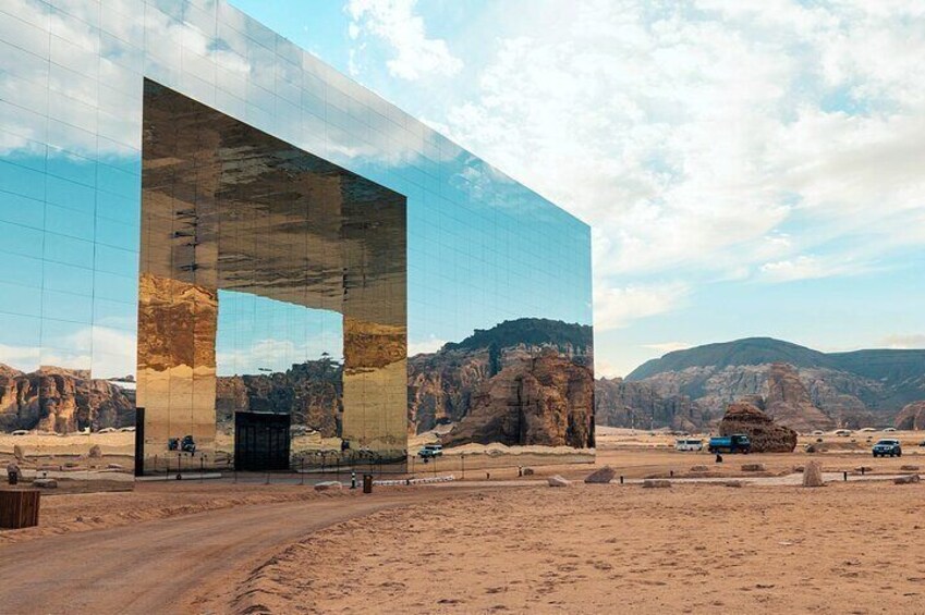 A modern building with a large glass facade reflecting the desert landscape. 2